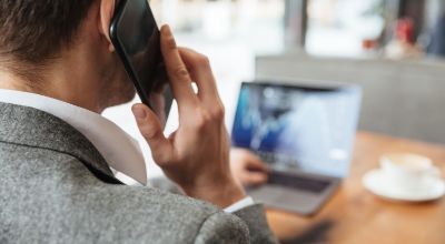 immagine-potata-dell-uomo-d-affari-che-si-siede-dalla-tavola-in-caffe-e-che-analizza-gli-indicatori-sul-computer-portatile-mentre-parlando-dallo-smartphone-concentrati-sull-uomo